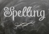 "Spelling" written in cursive on a chalkbaord